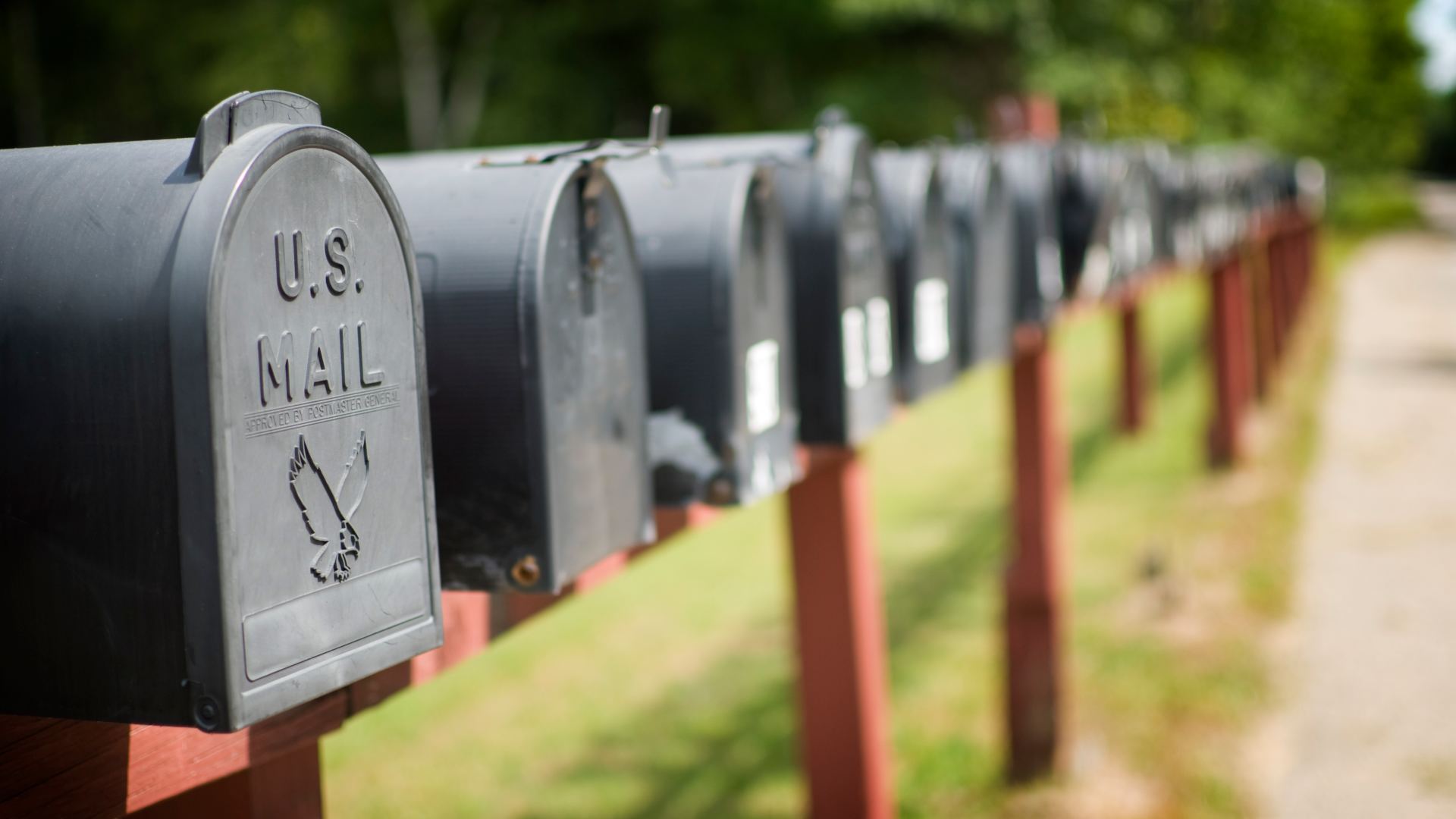 A row of well-kept mailboxes line a country road
